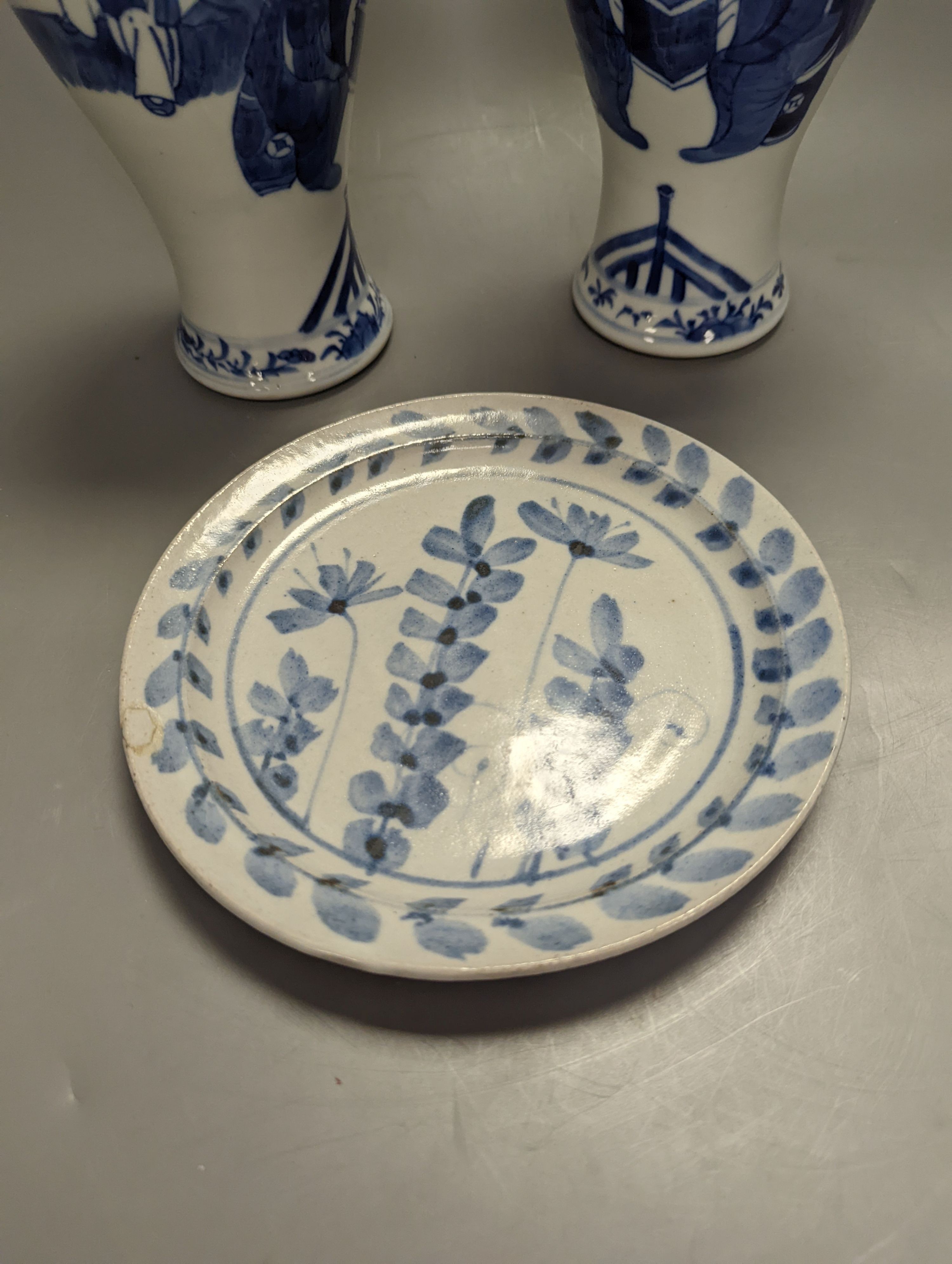 A pair of Chinese figural blue and white vases, drilled bases, height 25cm, and a plate